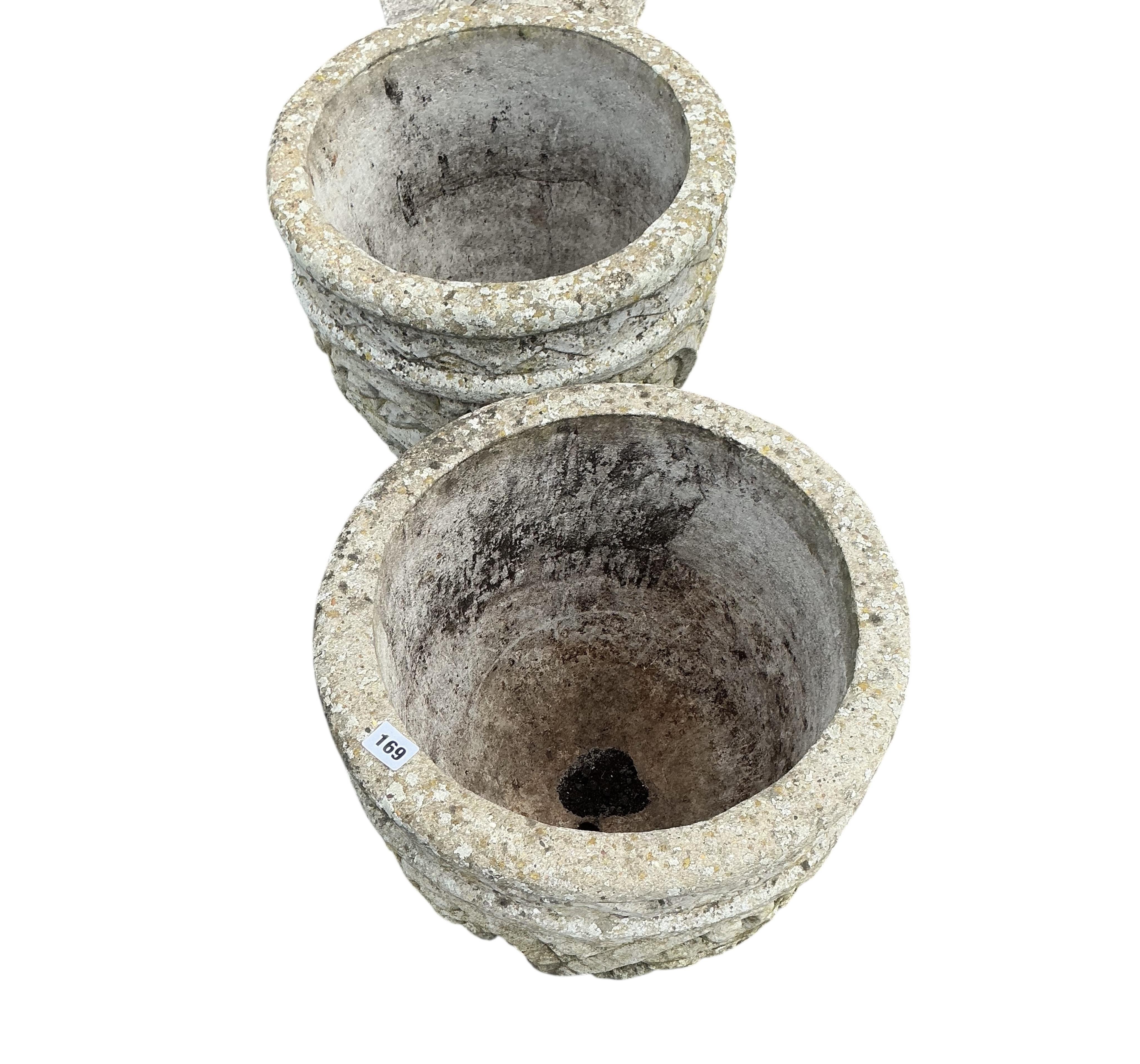 A pair of circular reconstituted stone garden planters with fruiting vine moulded bodies, diameter 40cm, height 38cm